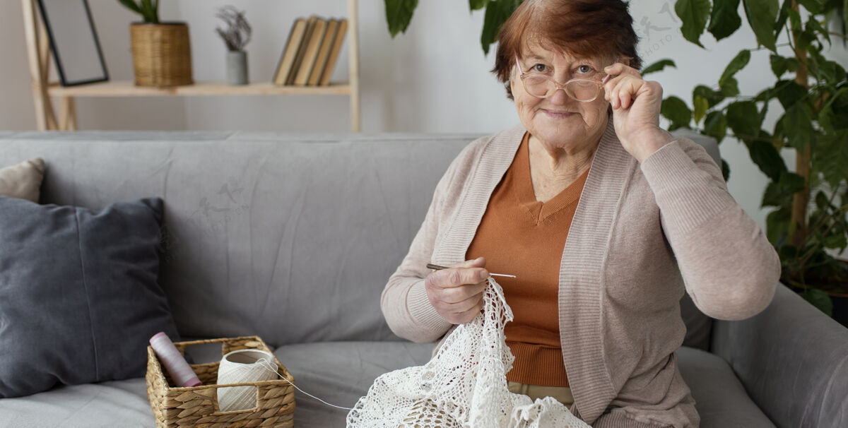 退休中等镜头的女人在室内钩针生活方式社会内部