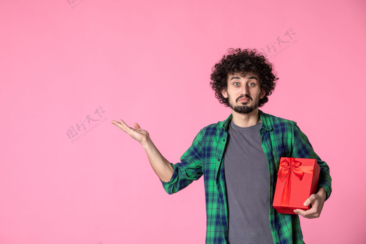 人浅粉色墙上红色包裹的年轻男性正面图衬衫蝴蝶结年轻人