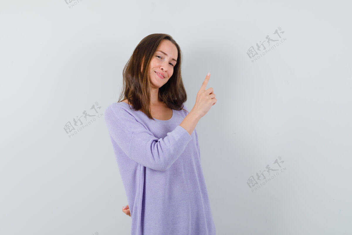女士一个穿着淡紫色上衣的年轻女人指着头 看上去很自信指向化妆漂亮