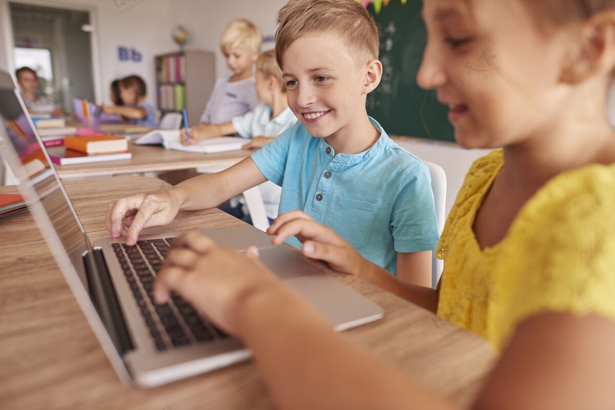 设备两个孩子在上课时用笔记本电脑帮助室内学习