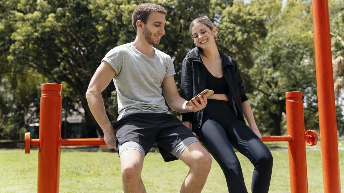 水平女人和男人在户外运动时带着智能手机锻炼锻炼男人