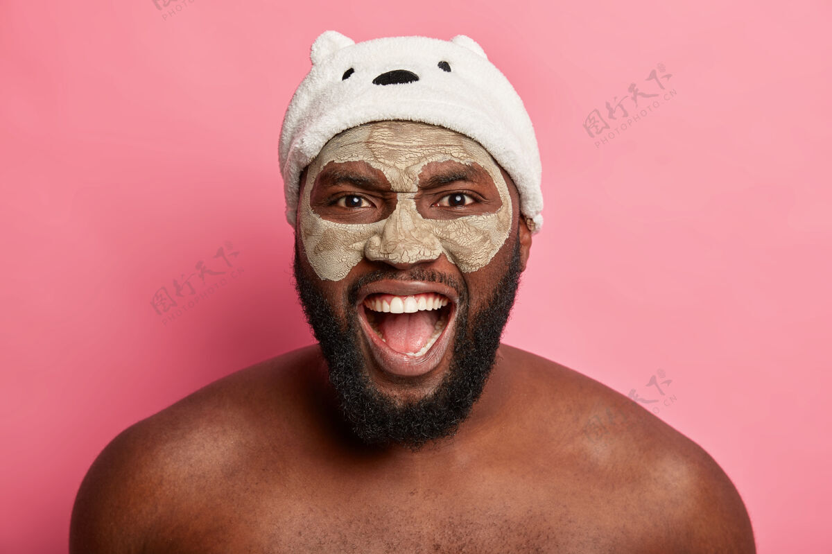 粘土美国黑人戴着泥面具 表达积极情绪赤膊上阵站立面部护理