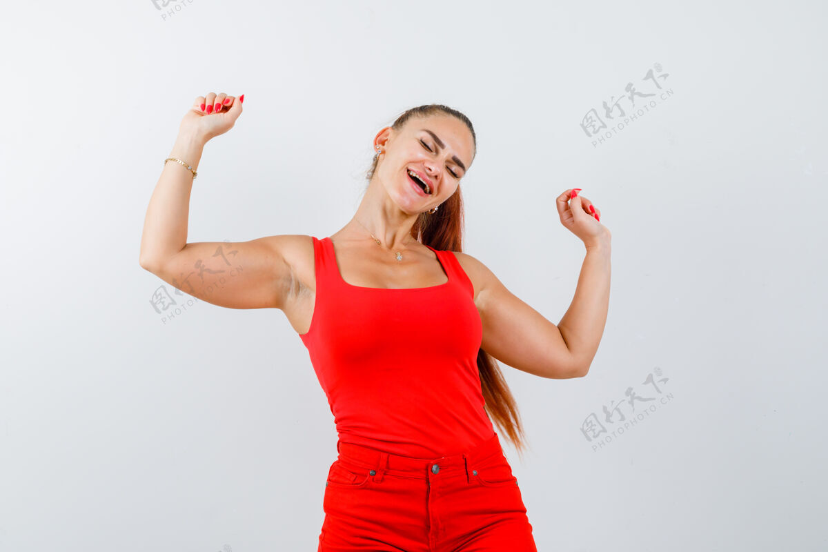 女孩身着红色背心 裤子 神采奕奕的年轻女子展示着赢家的姿态模型快乐欢呼