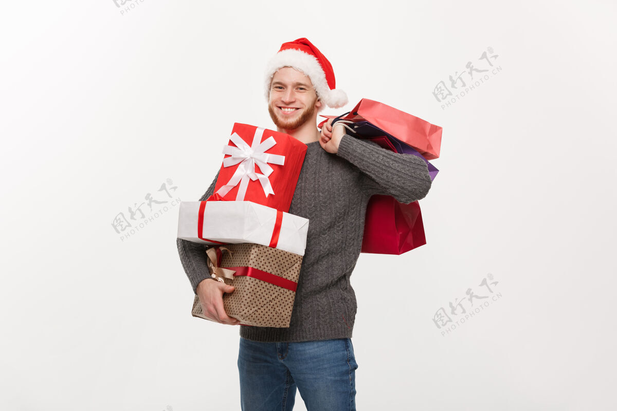 年轻人一个留着胡子的年轻帅哥 手里拿着很多礼物和购物袋 脸上露出幸福的白色表情礼品盒帅哥消费者