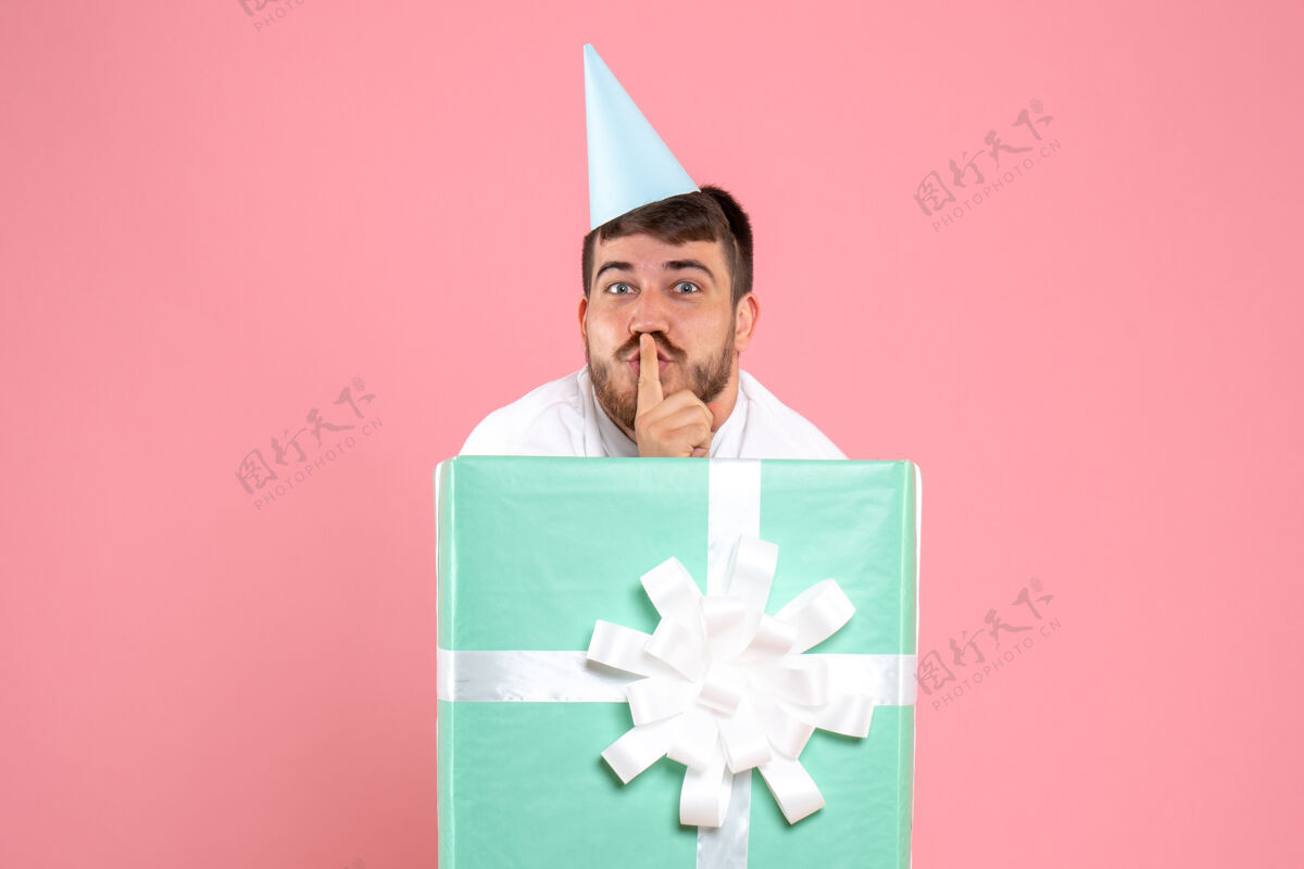 礼物正面图：年轻男性站在礼物盒内的粉色照片颜色情感圣诞睡衣派对情感帽子正面