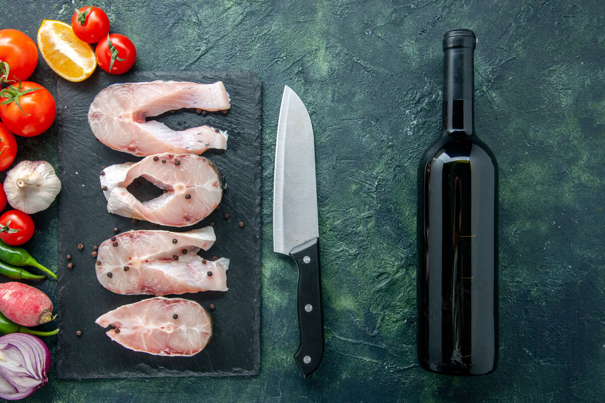 刀片顶视图新鲜鱼片与红色番茄在黑暗的背景海洋肉类海鲜海餐水食品辣椒菜葡萄酒景观肉海鲜