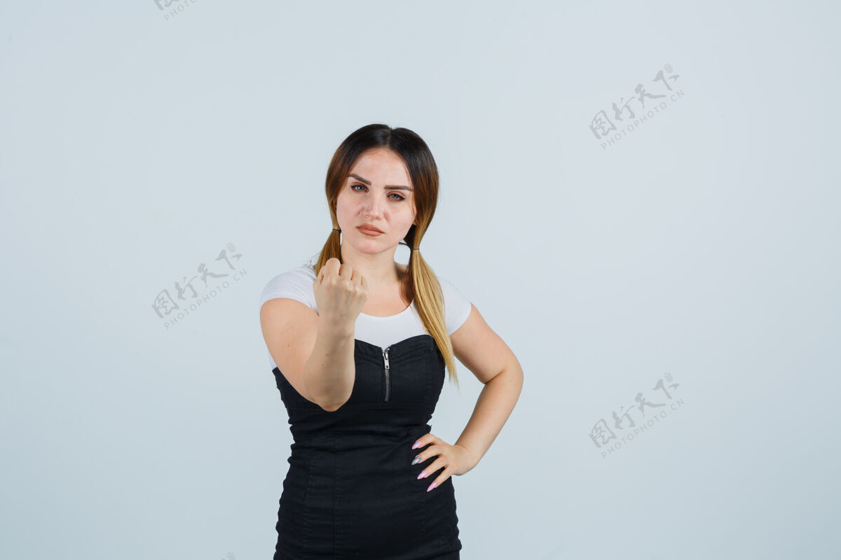 沮丧一个穿着裙子的金发女郎在孤立地做手势年轻女性拳头