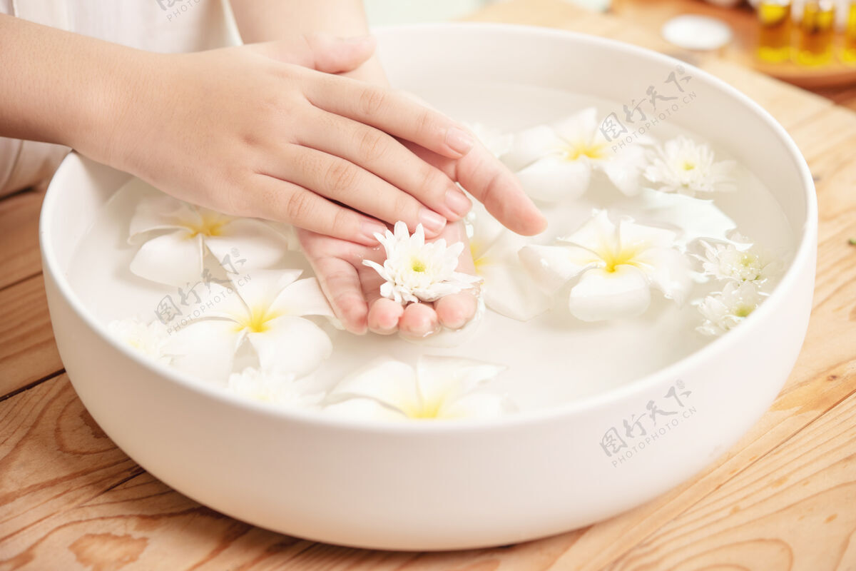 纯洁水疗治疗和产品在水疗香薰水疗陶瓷碗白花女性放松手