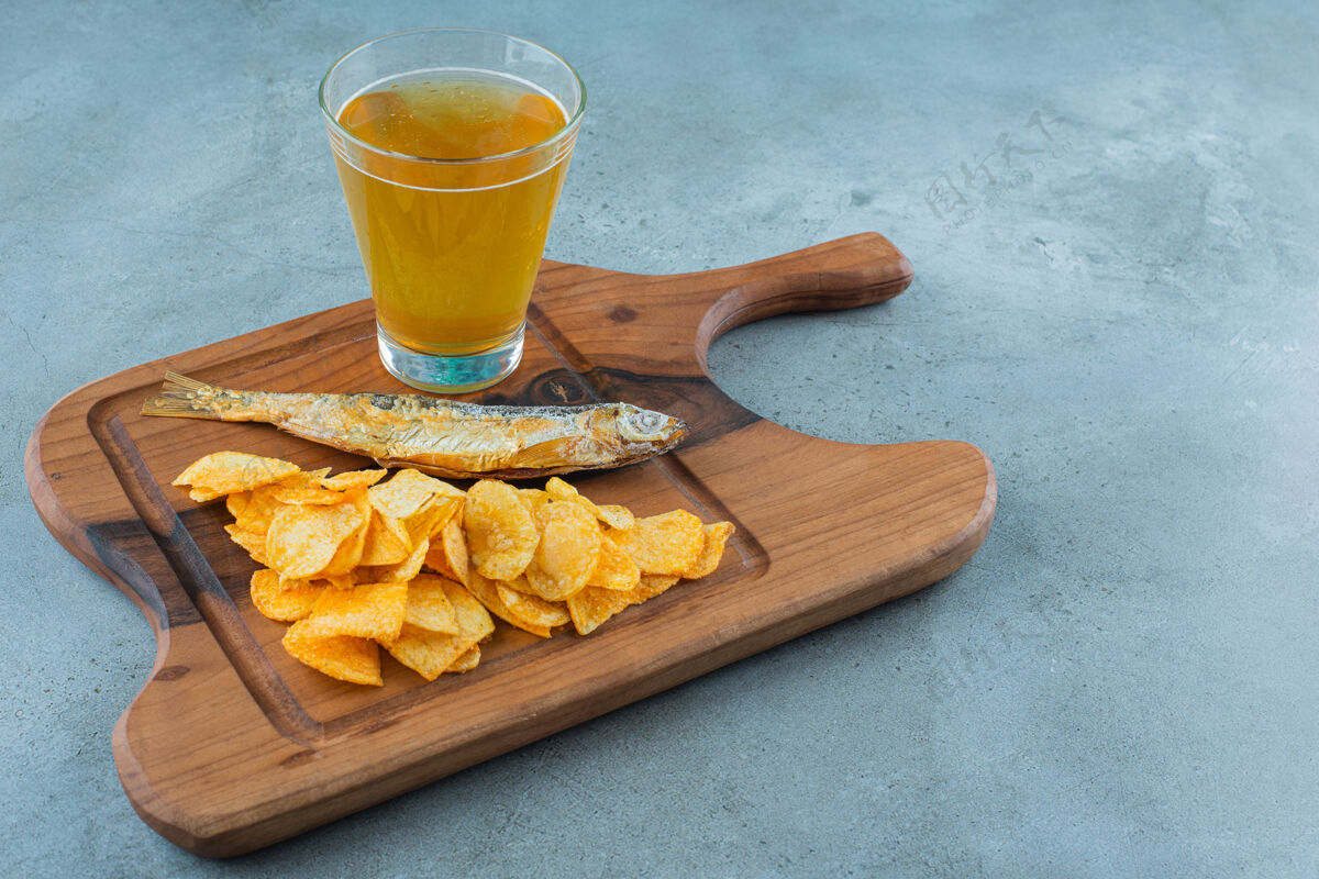 美味薯条 鱼和一杯啤酒放在木板上 大理石背景上酒精板美味
