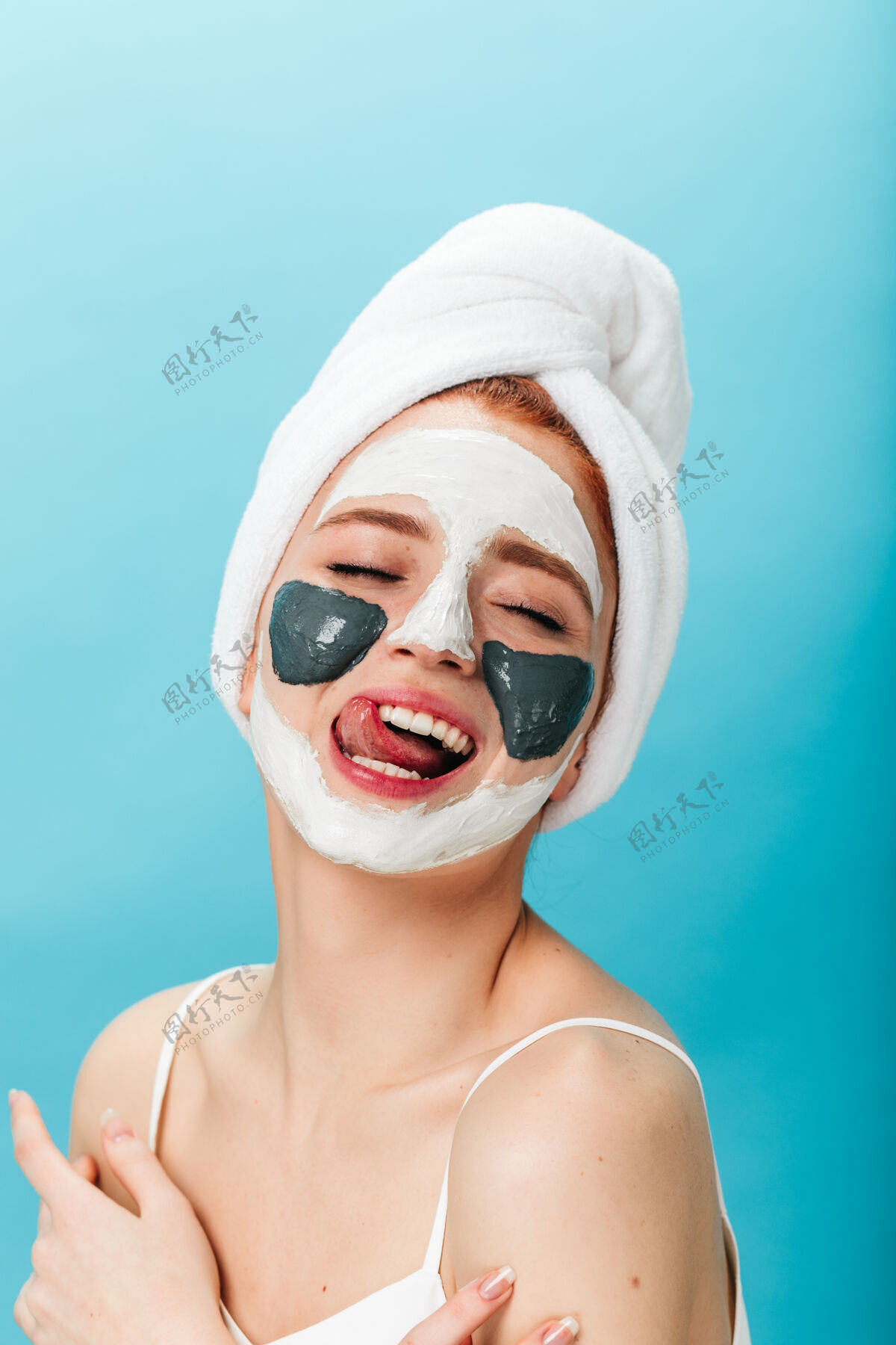 皮肤护理美丽的女人在护肤过程中玩得很开心摄影棚拍摄的蓝色背景上戴着面具的漂亮女孩的姿势女孩水疗皮肤