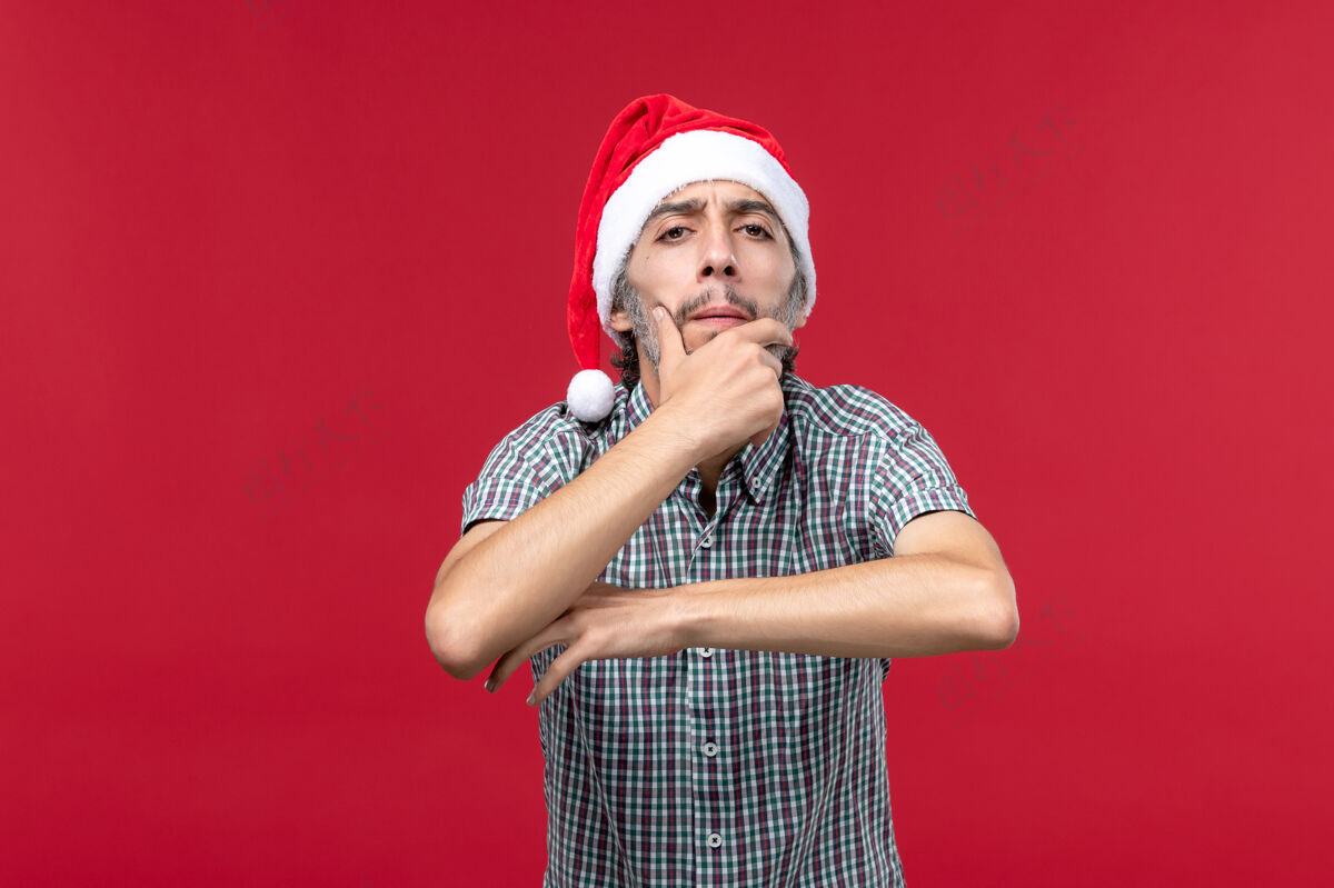 音乐家正面图年轻人带着思考的表情在红墙假日新年红人圣诞节思想