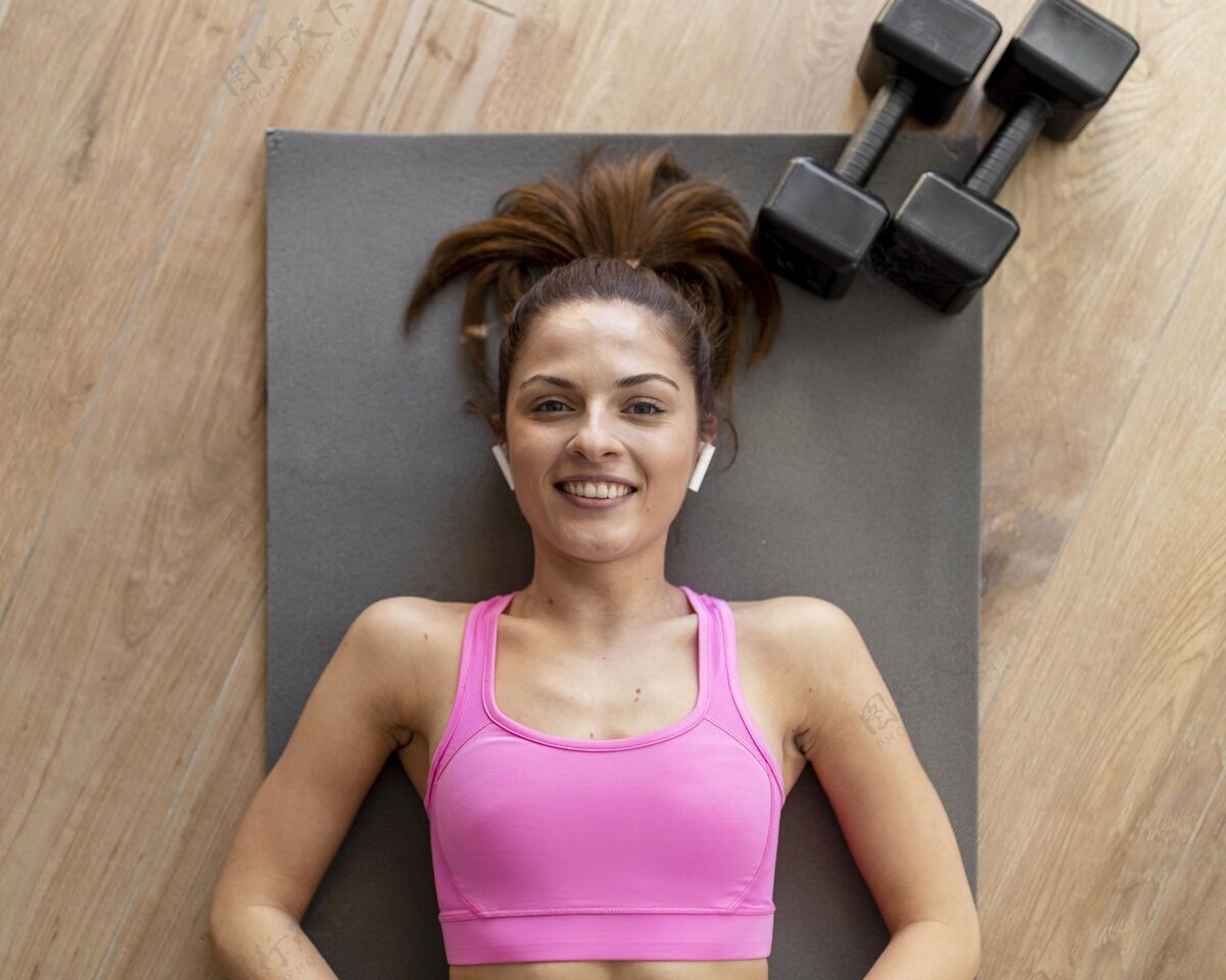 锻炼中枪笑脸女人躺在瑜伽垫上女性健康保健