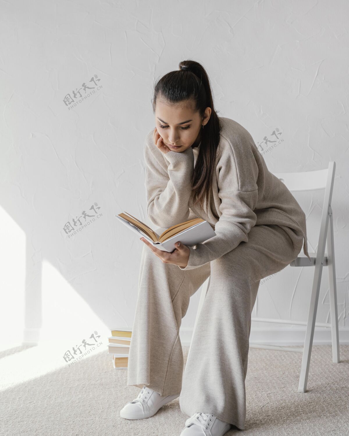 垂直坐在椅子上看书的女人年轻休闲女人