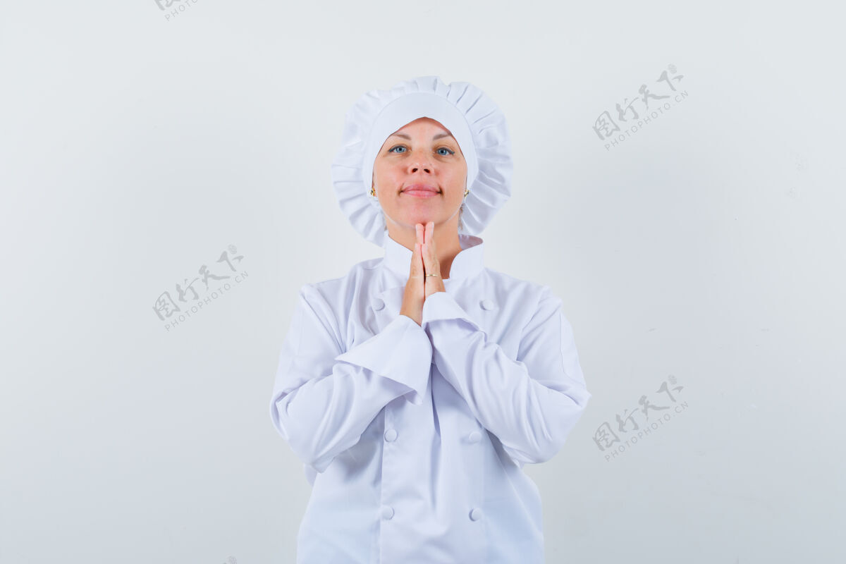 希望身穿白色制服的女厨师手牵手祈祷 看上去充满希望时尚模特手