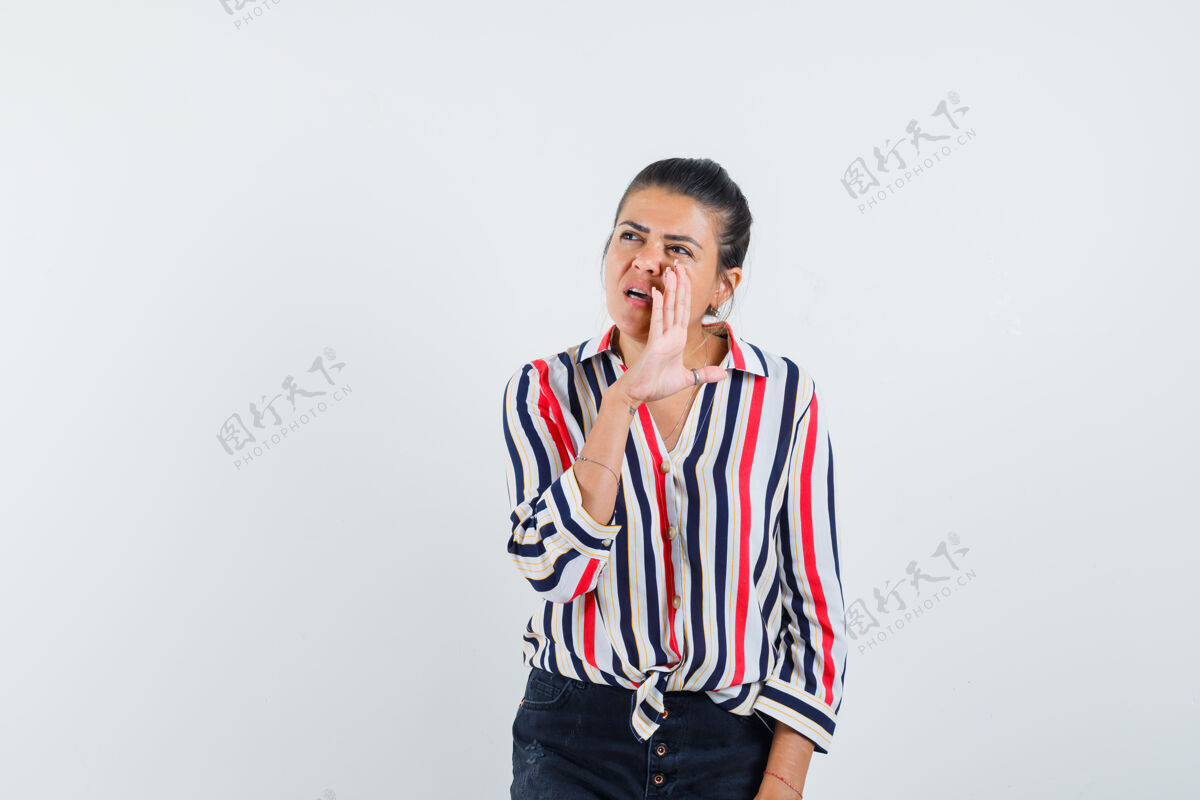 护理年轻的女人把手放在嘴边 叫着一个穿着条纹衬衫的人 看上去很好奇 人黑发女性