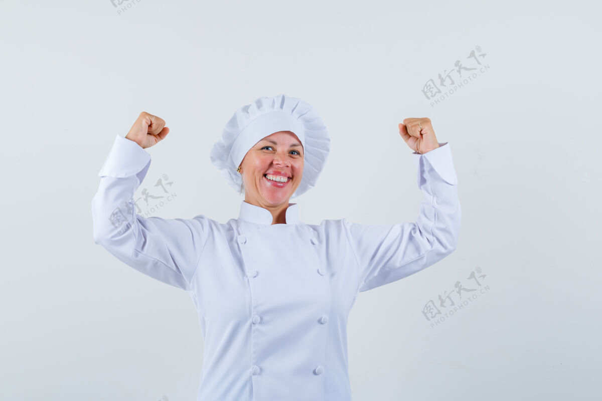 肖像一位身着白色制服的女厨师摆出赢家的姿态 看上去很开心年轻化妆品喜悦