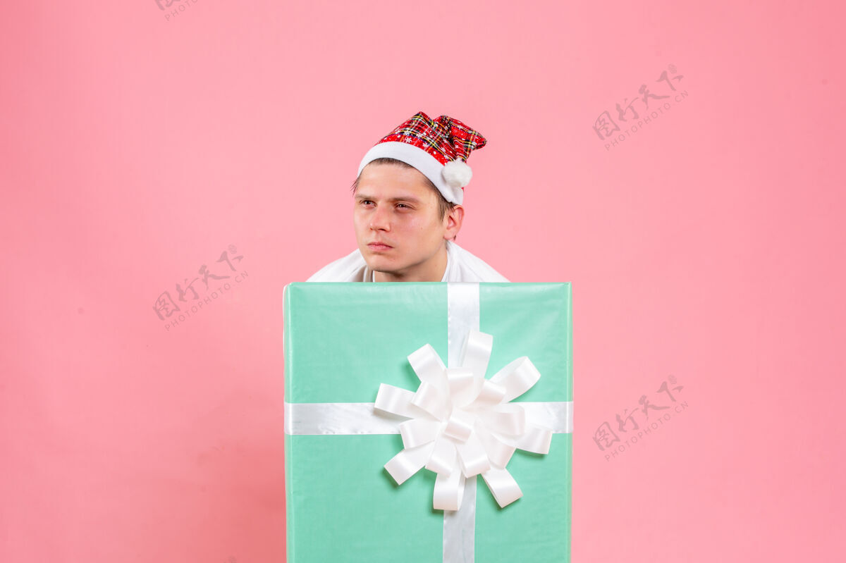 外观正面图：身穿白色衬衫的年轻男性 粉色背景的礼物粉色盒子礼物