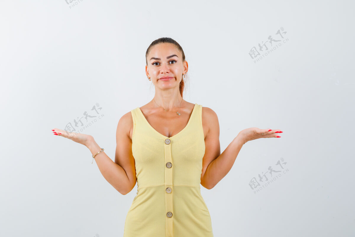 思考一位身穿黄色连衣裙的年轻女士表现出无助的姿态 看上去很困惑前视图肖像问题女人