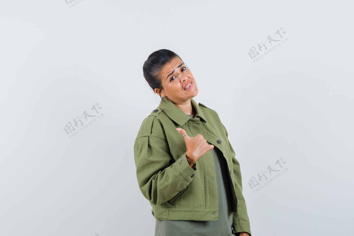 自然一个穿着夹克衫的女人 t恤衫上竖起大拇指 看上去犹豫不决外观美容脸