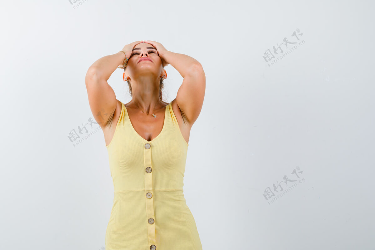 抱着穿着黄色衣服的年轻女士手举在头上 看起来精疲力尽 正面视图痛苦压力前面