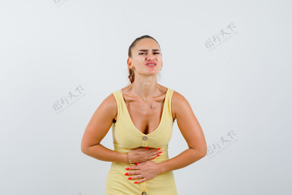 随意身穿黄色连衣裙的年轻女士胃痛难忍 看上去很痛苦 正面图厕所女人健康