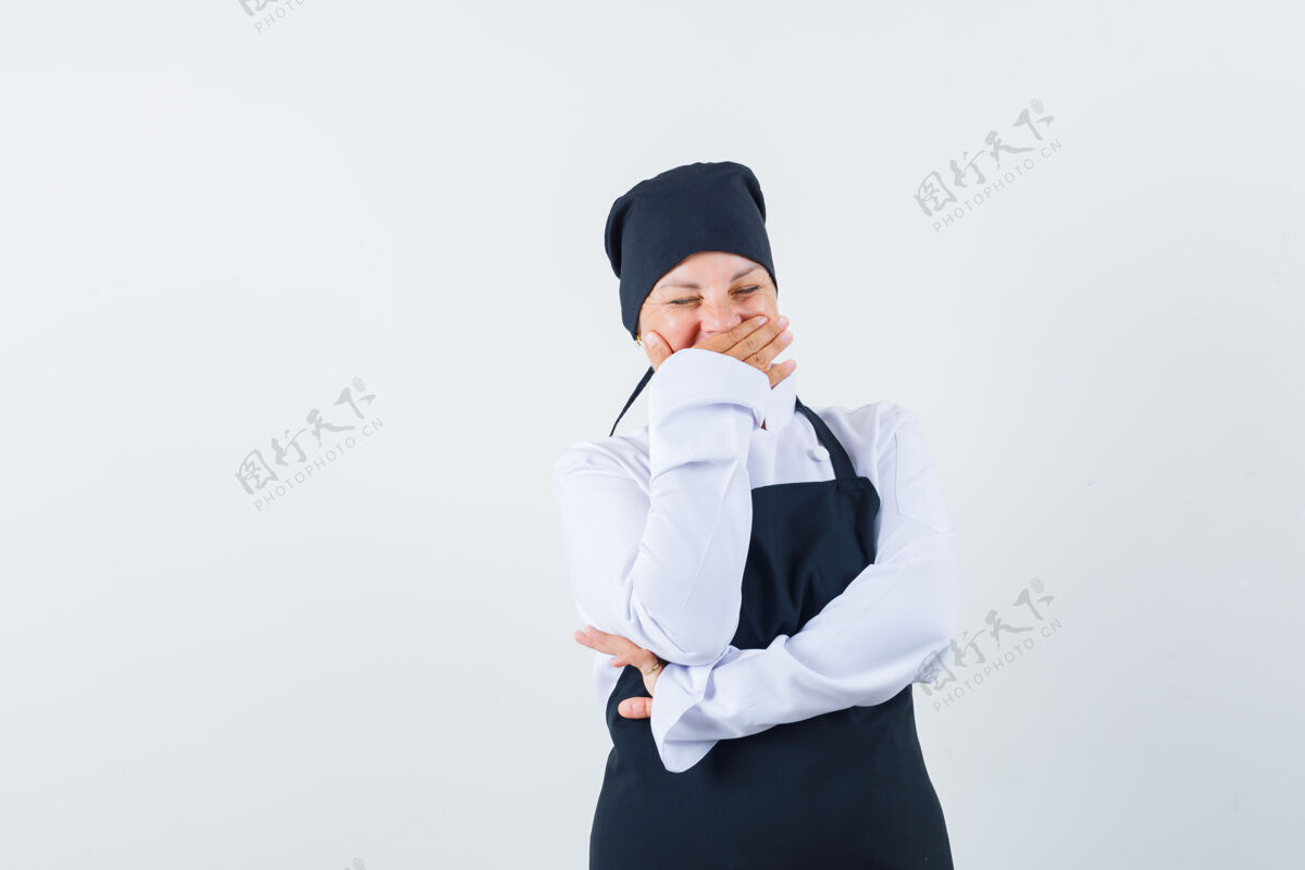 制服穿着黑色厨师制服的金发女人用手捂住嘴 看起来很开心魅力脸女性
