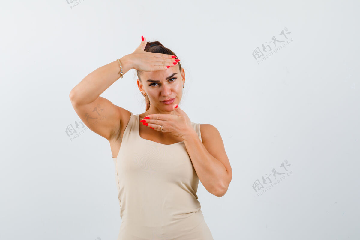 皮肤护理年轻的女性在米色背心使框架姿态和看起来很有吸引力 前视图人清洁前面