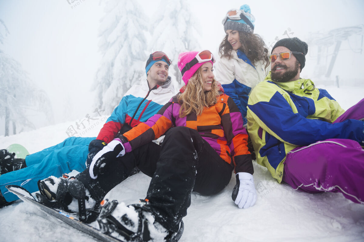 坐着两对情侣在玩滑雪雪动作女人