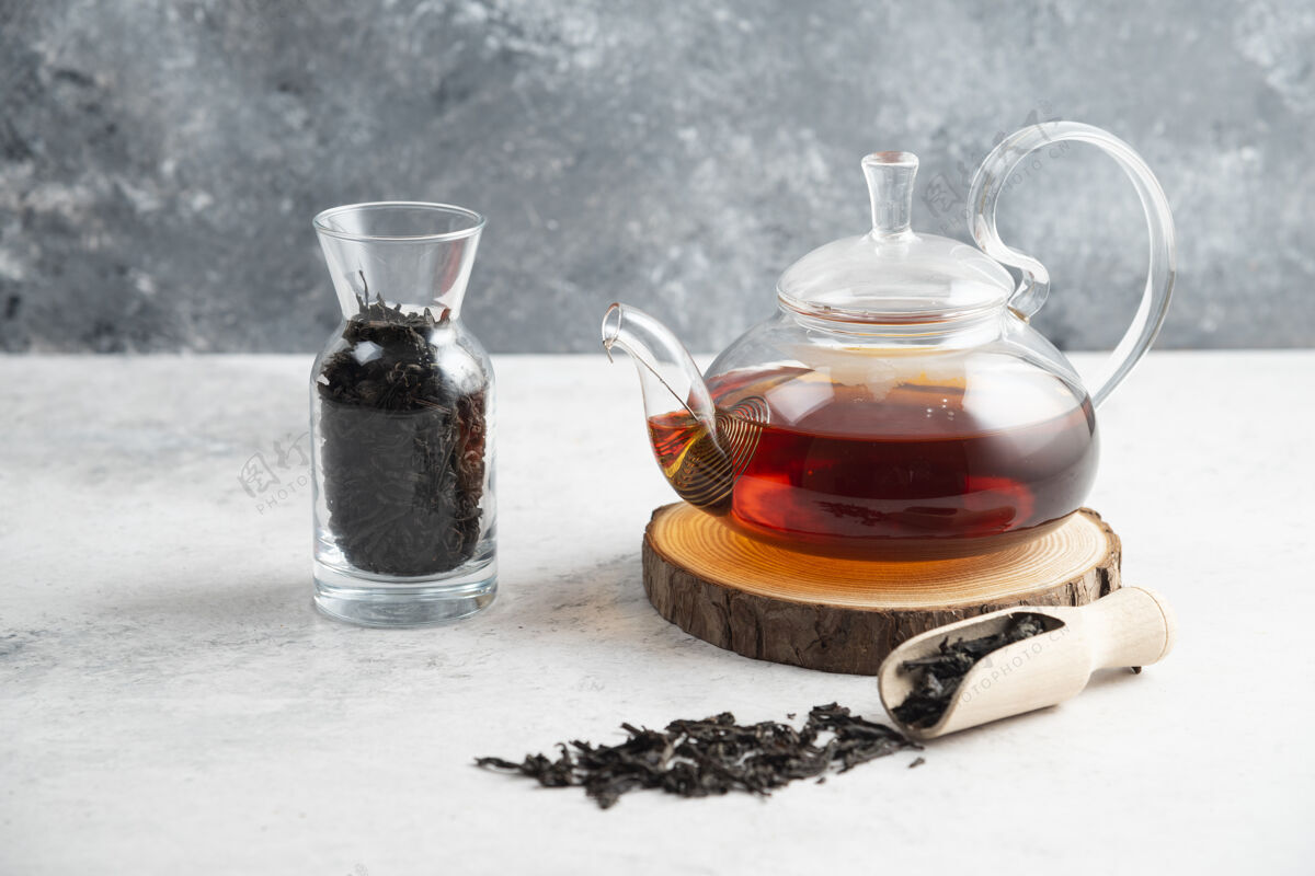木一个玻璃茶壶 里面放着干的散茶和一个木勺草药芳香玻璃
