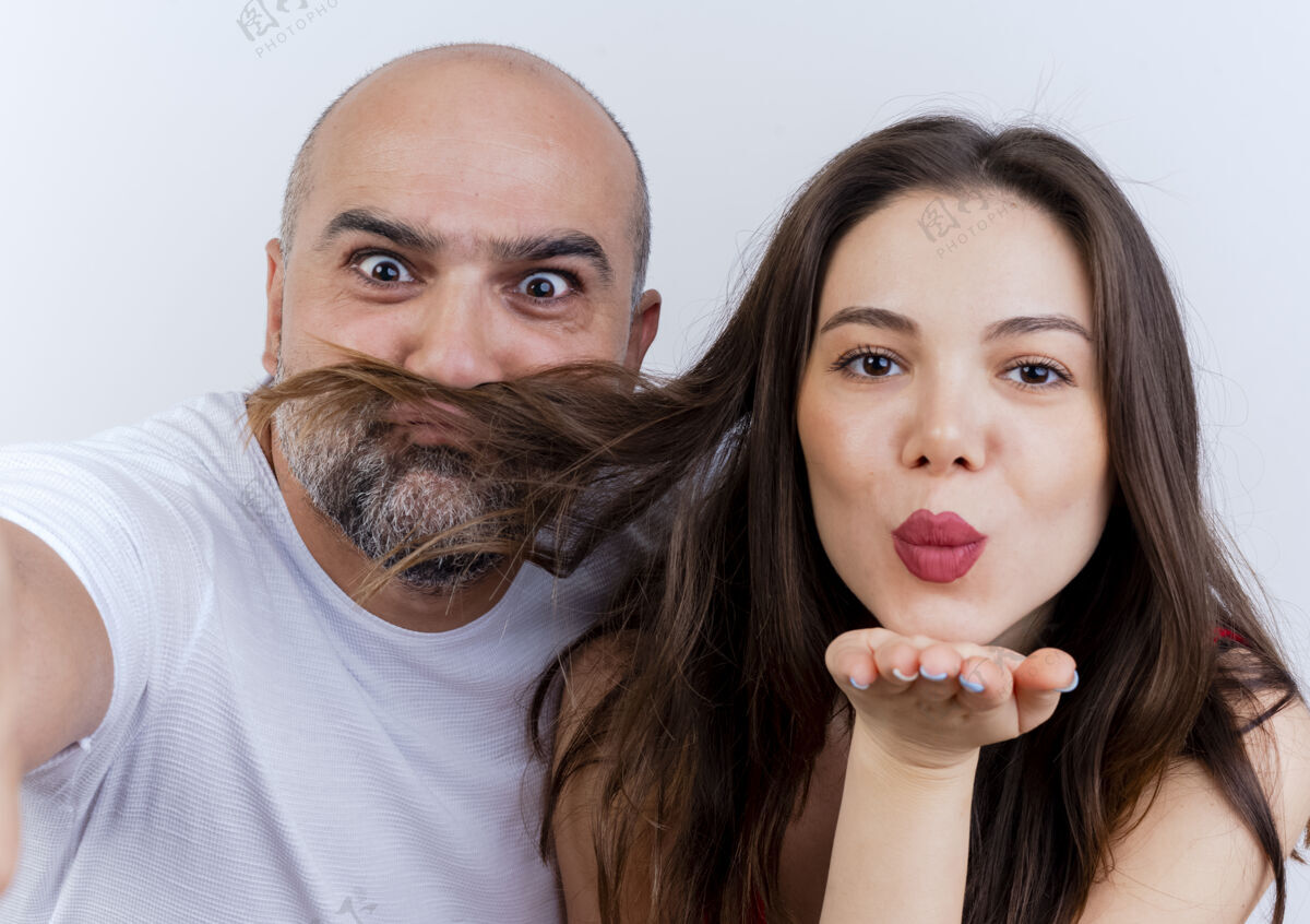 亲吻成人夫妇的特写镜头嬉戏的男人从女人的头发和女人发送吹吻胡子观看成人玩