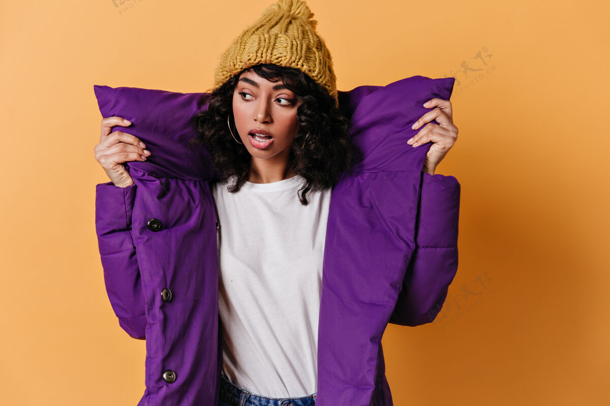 欢呼一个穿着紫色羽绒服的性感的年轻女人在看别处冬季模特成人