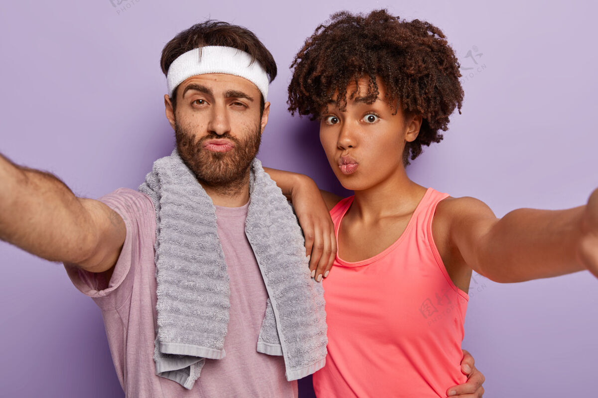 胡茬照片中的运动男女伸出双手 自拍肖像 双唇合拢 身着运动服 肩上搭软毛巾健身男发型