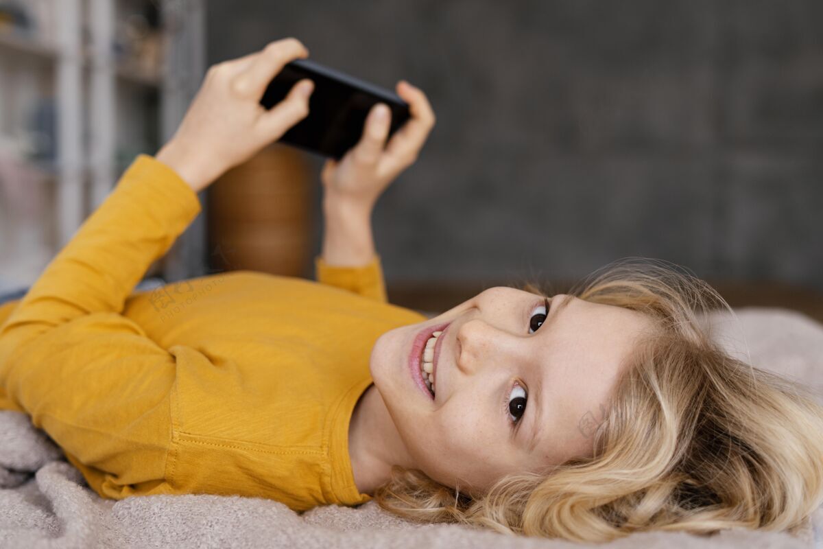 小玩意孩子在床上玩手机科技设备手机