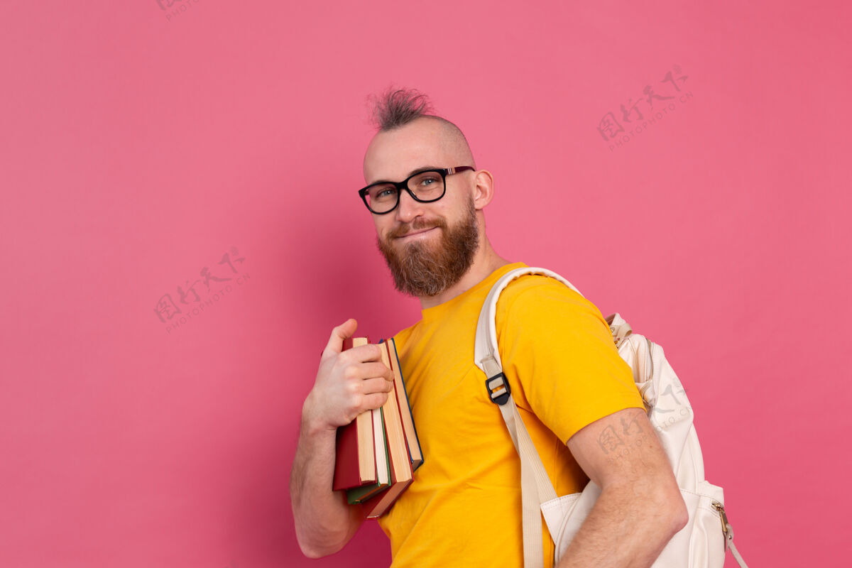时尚一个留着胡子 背着书包 拿着书 穿着休闲装 快乐的成人学生自我现代保持