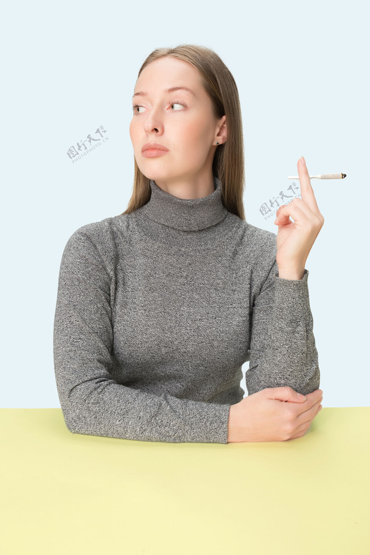 香烟那个坐在演播室桌子旁抽烟的年轻女人吸烟室内烟草
