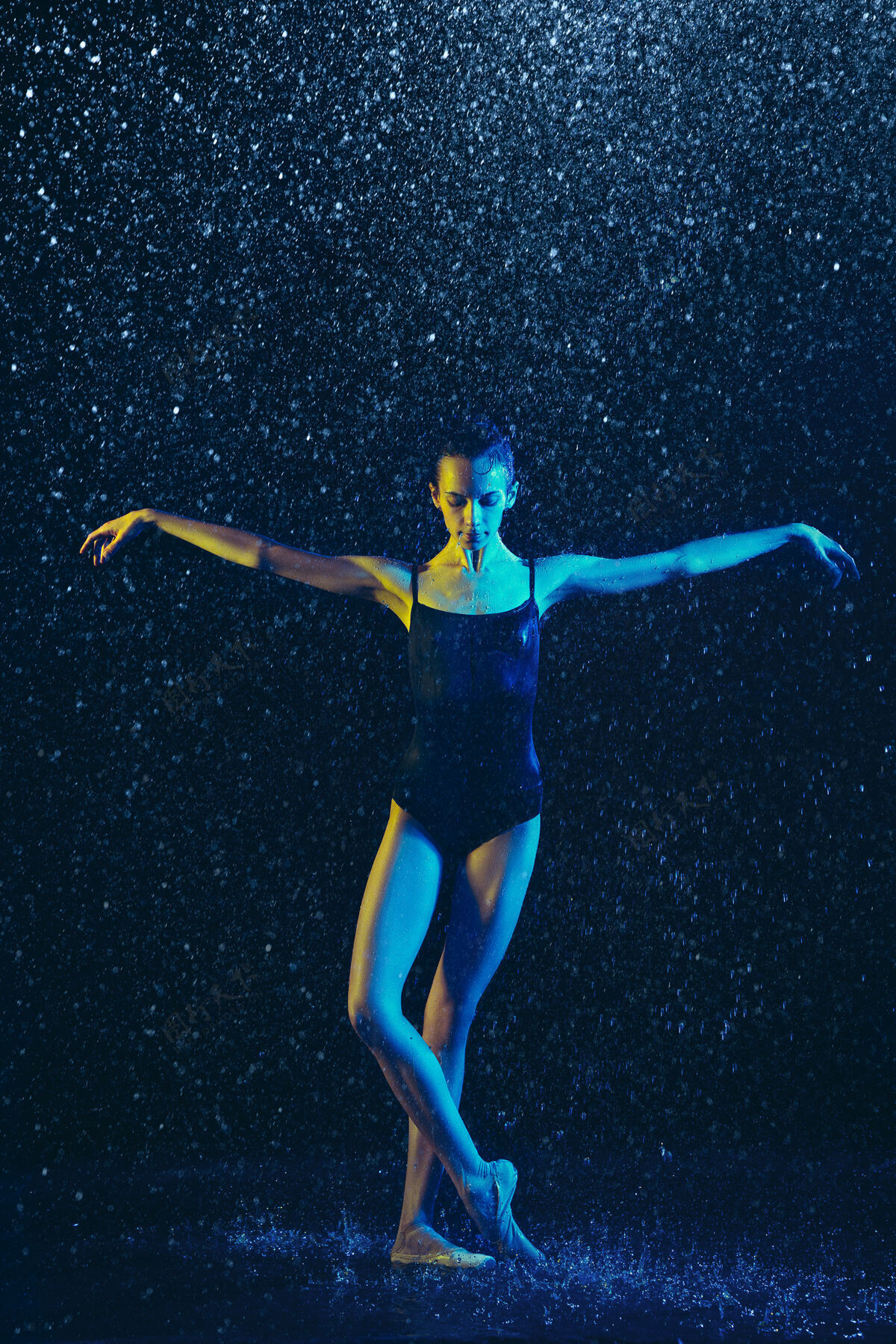 飞溅年轻的女芭蕾舞演员在水滴和浪花下表演白种人模特在霓虹灯下跳舞迷人的女人芭蕾舞和当代舞蹈概念水芭蕾舞喷雾