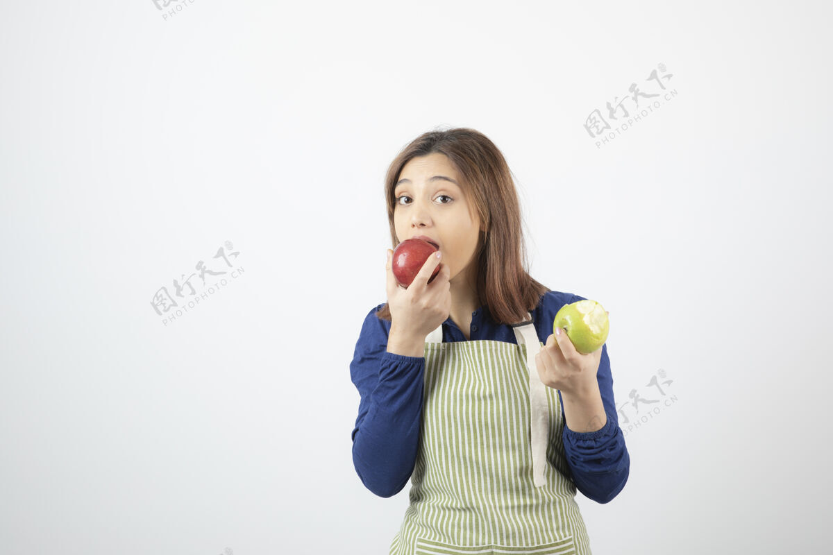 人类穿着围裙拿着苹果的可爱的年轻女模特女人人水果