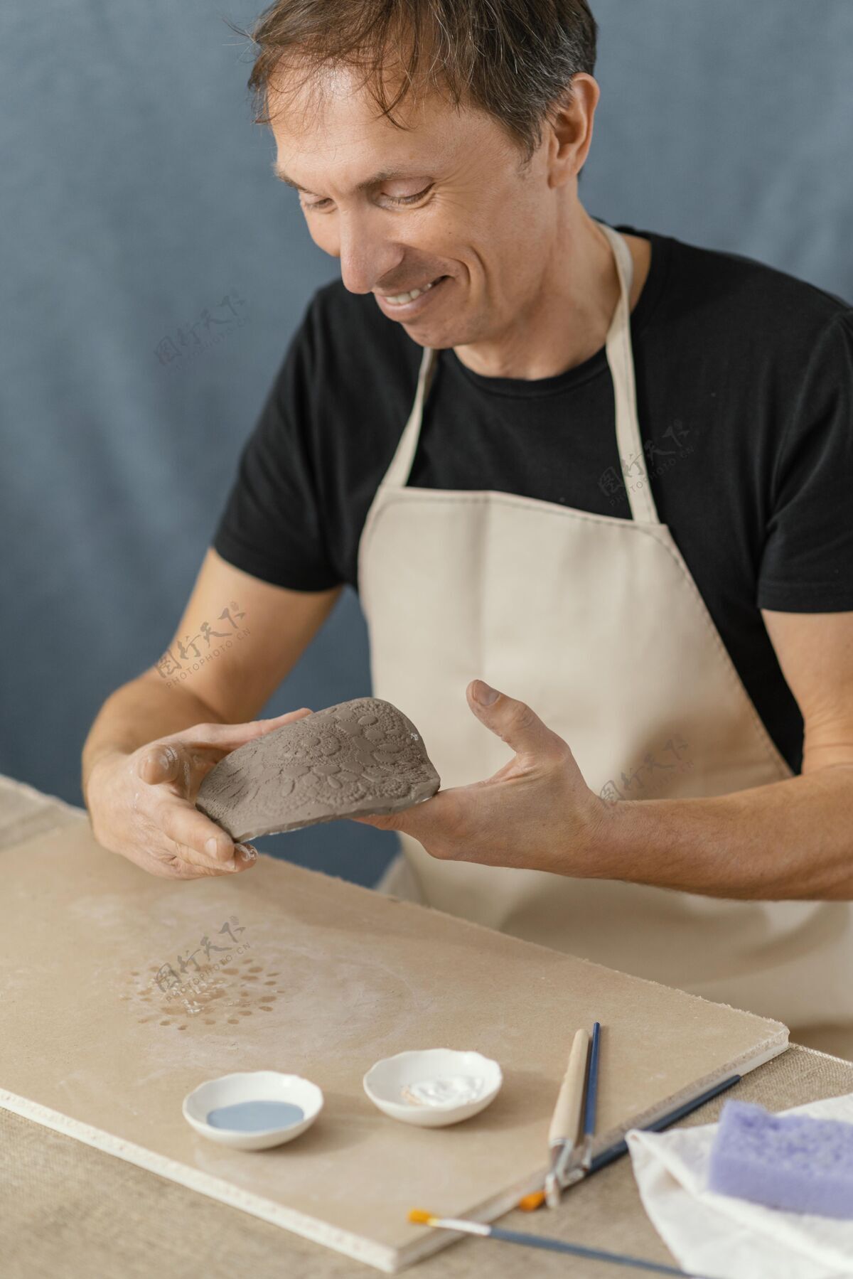 艺术家特写笑脸人做陶器垂直男性爱好