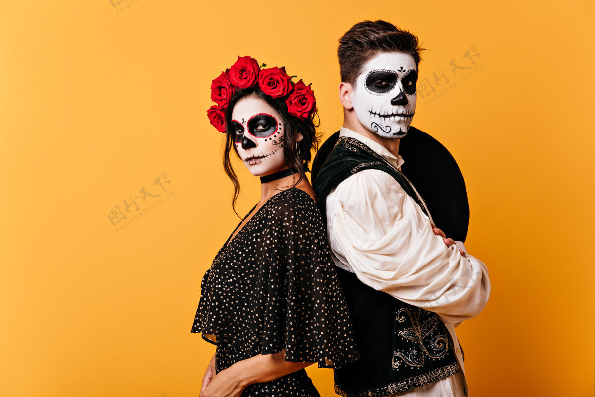 玫瑰一对自豪的墨西哥夫妇身着传统服装 脸上涂满了颜料头发上插着玫瑰的女孩和背着浓密睡衣的年轻人合影死亡墨西哥传统