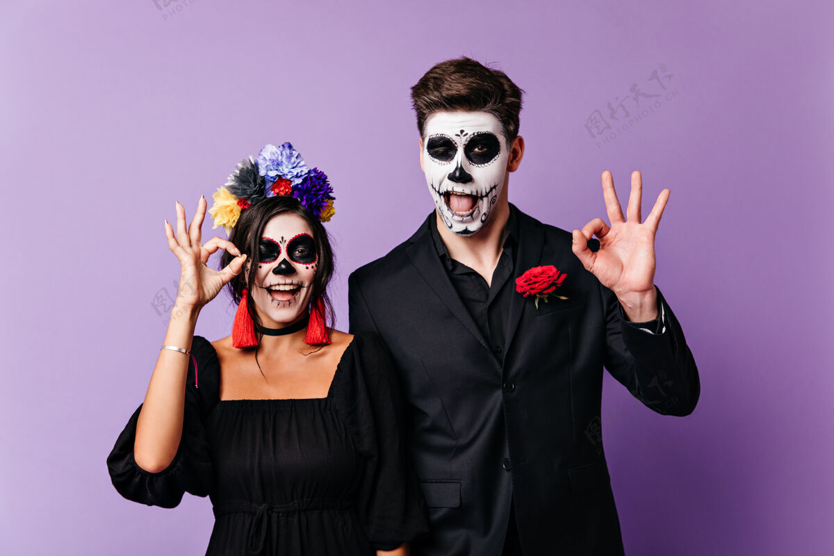 幽灵快乐的深色头发的男孩和女孩微笑 并显示标志好墨西哥快乐的女士和男子画像画的脸西班牙玫瑰五颜六色