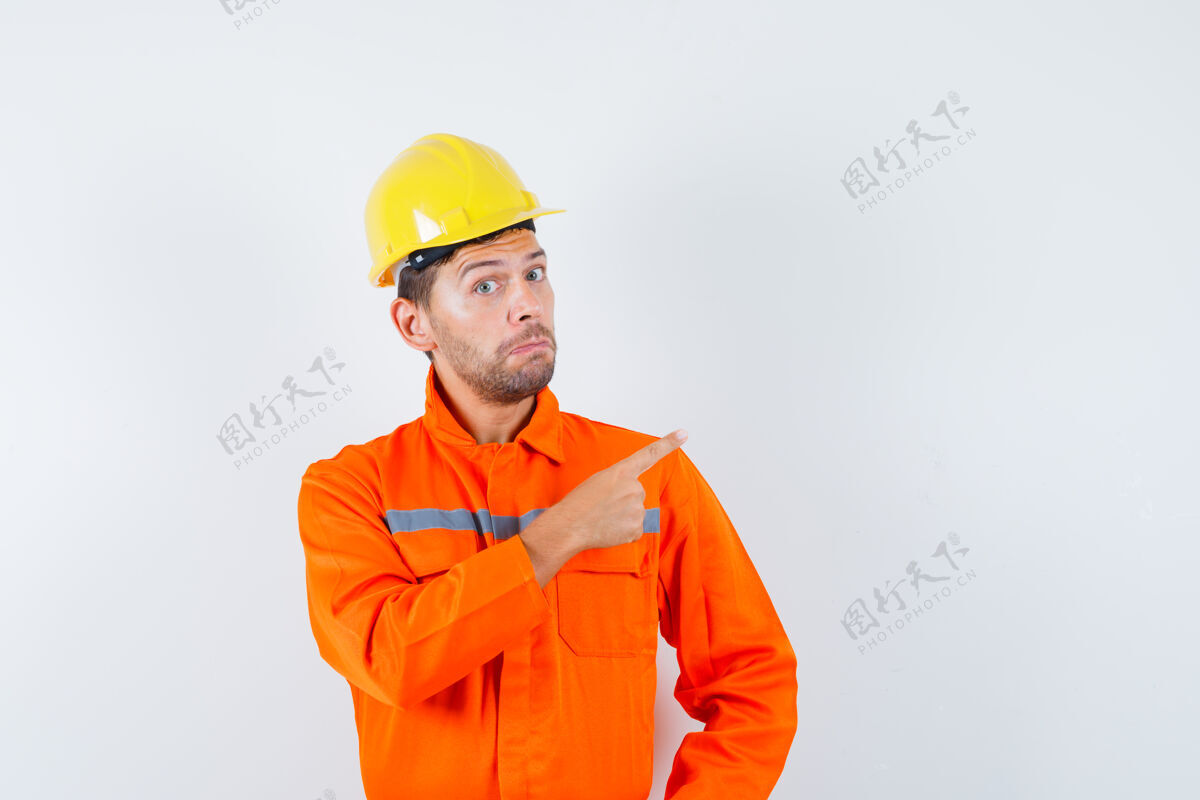 犹豫建筑工人指着远处的制服 戴着头盔 神情犹豫不决 眼前一亮起重机土建承包商