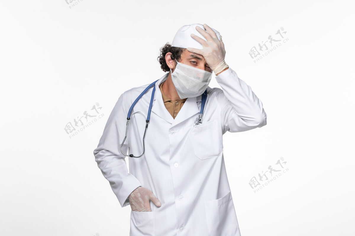 正面正面图男医生穿着医疗服 戴着无菌口罩 以防柯维德强调白壁病毒引起的冠状病毒大流行疾病穿着压力冠状病毒
