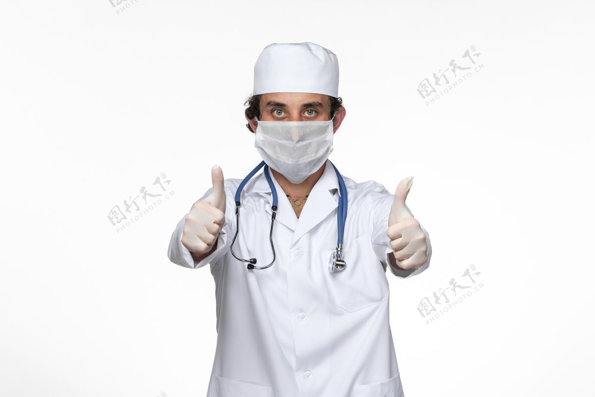 冠状病毒正面图身穿医疗服的男医生戴着口罩 以防白墙病毒传染男性穿着套装