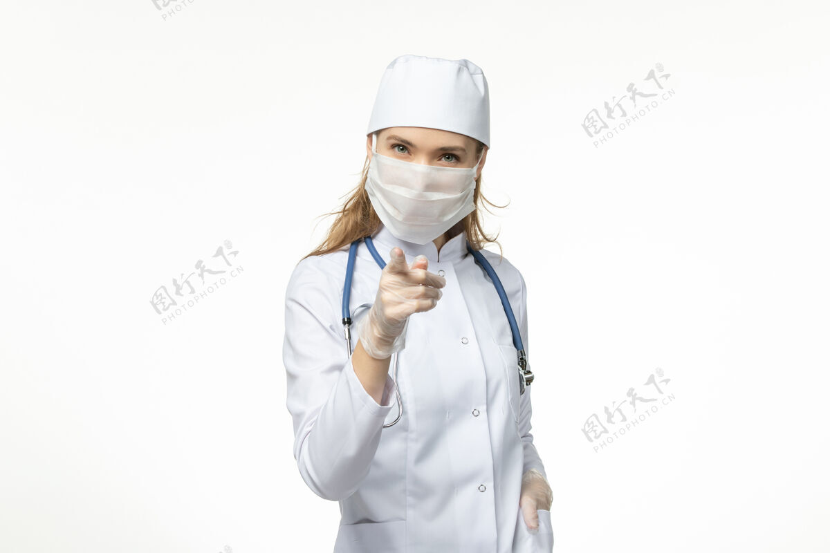 面罩正面图女医生穿着医疗服戴着口罩和手套因冠状病毒在白墙上冠状病毒-大流行性疾病病毒病医疗冠状病毒到期