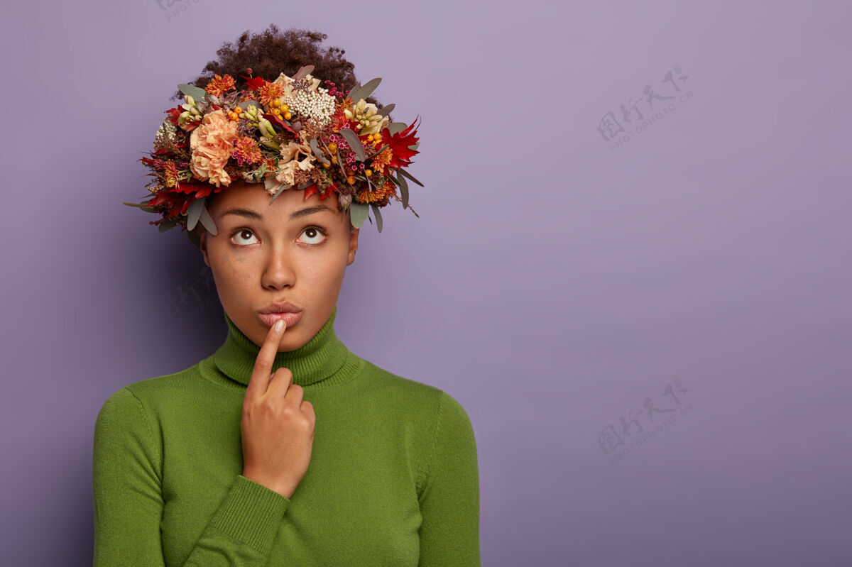 向上体贴的黑皮肤女人横拍有悲伤的表情 聚焦在上面 手指放在嘴唇上 戴着秋天植物做的漂亮花环 有沉思的表情 努力做出正确的决定温柔紫罗兰思考