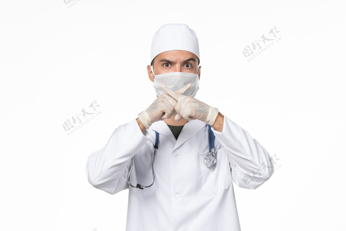西装正面图：男医生穿着医疗服 戴着口罩 因为白色墙壁上有病毒性传染病病毒面具外套