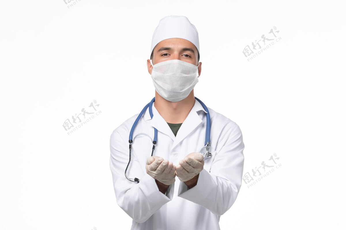 地板正面图男医生穿着医疗服 戴着口罩 因为白色地板上有冠状病毒-病毒大流行病毒病冠状病毒防护冠状病毒预防视图