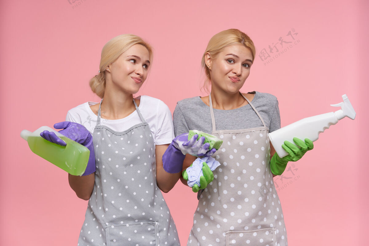 妹妹年轻的金发可爱的主妇们戴着橡胶手套准备春季大扫除金发洗洁精女性
