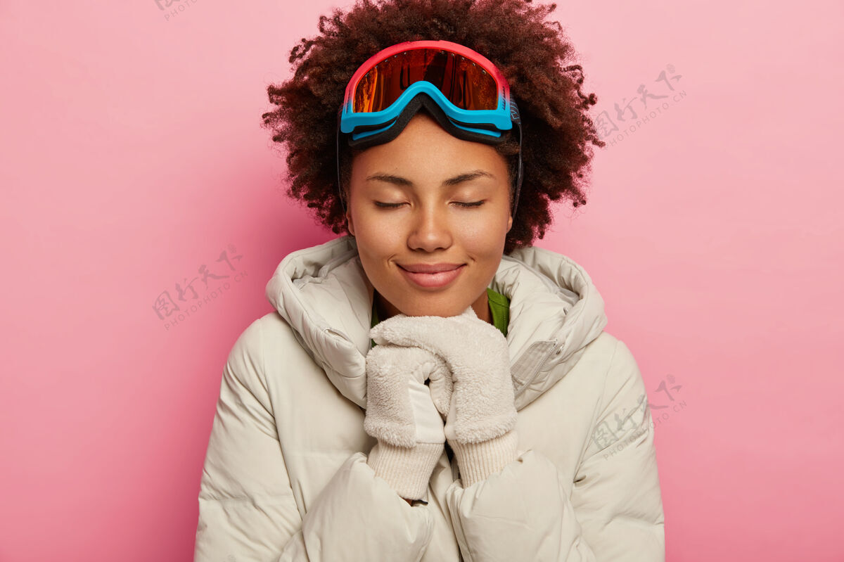 罗西健康可爱的卷发女人 穿着白色羽绒服和手套 戴着滑雪面罩 闭上眼睛面具冬天室内