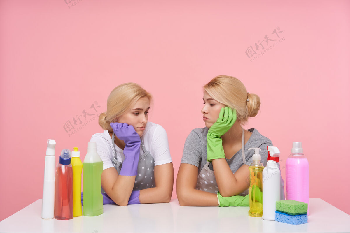 双胞胎年轻的金发可爱的主妇们戴着橡胶手套准备春季大扫除洗涤剂漂亮女士